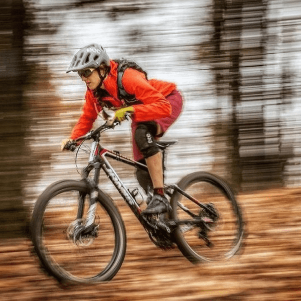 A biker riding fast in the woods